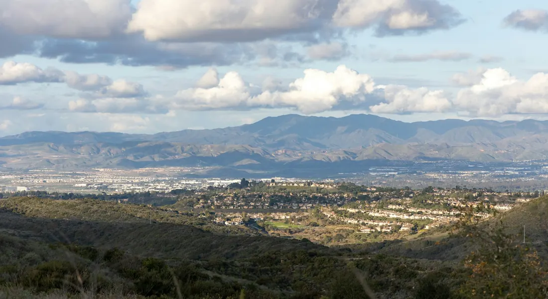 Hills and neighborhoods of Laguna Hills with mountains in the distance