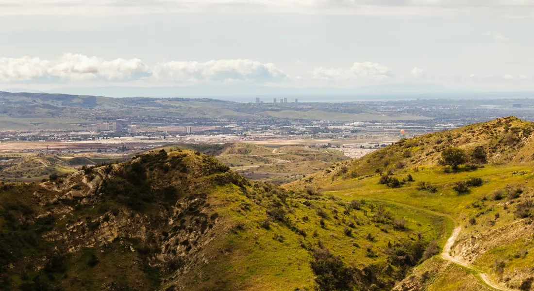 Hiking trail over rolling hills with the Orange County coastal plain beyond